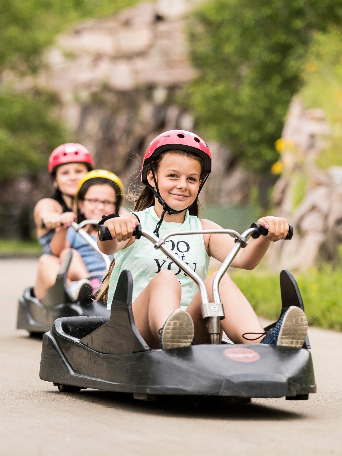 A girl smiles as she rides around a corner on the Skyline Luge Mont Tremblant track.