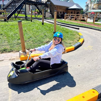 A lady smiles and poses for a photo as she finishes her Luge ride.