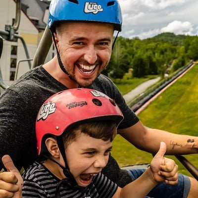 A father and son excited on the chairlift ready to ride the Luge.