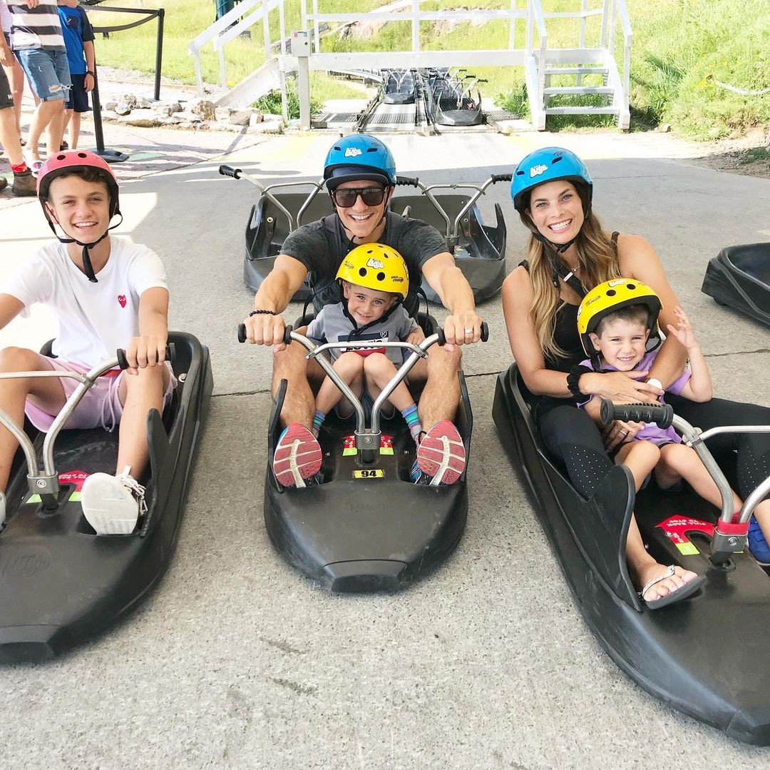 A family poses for a photo in their Luge carts ready to ride the tracks.