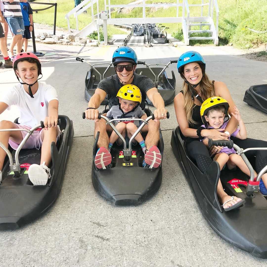 A family poses for a photo in their Luge carts ready to ride the tracks.