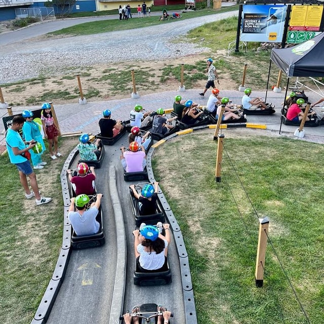 A large group of people reach the end of Luge tracks at Mont Tremblant.
