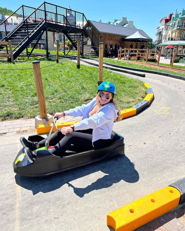 A lady smiles and poses for a photo as she finishes her Luge ride.